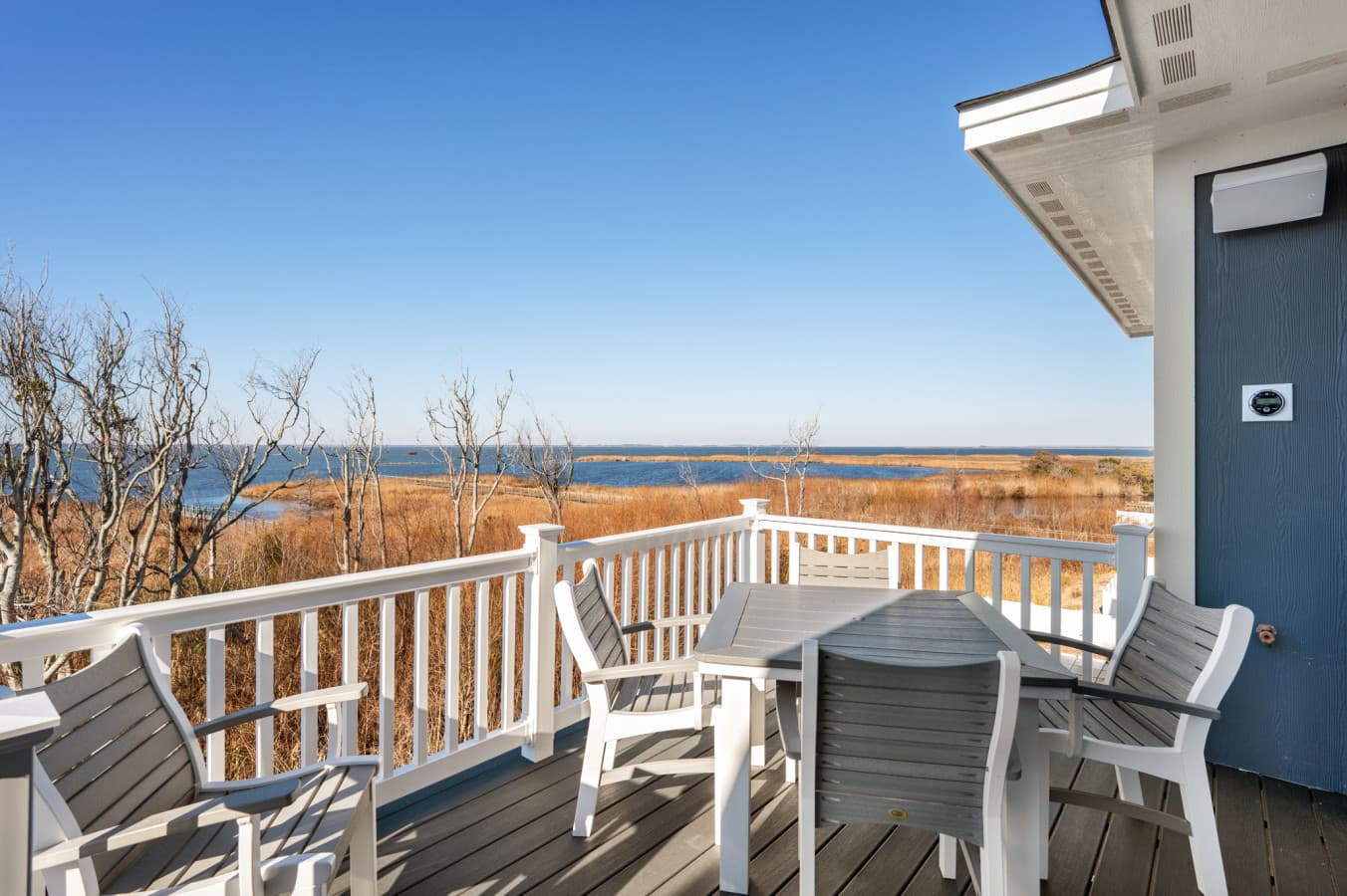 Covered deck seating w/ coastal views, perfect for morning coffee or sunset unwinding
