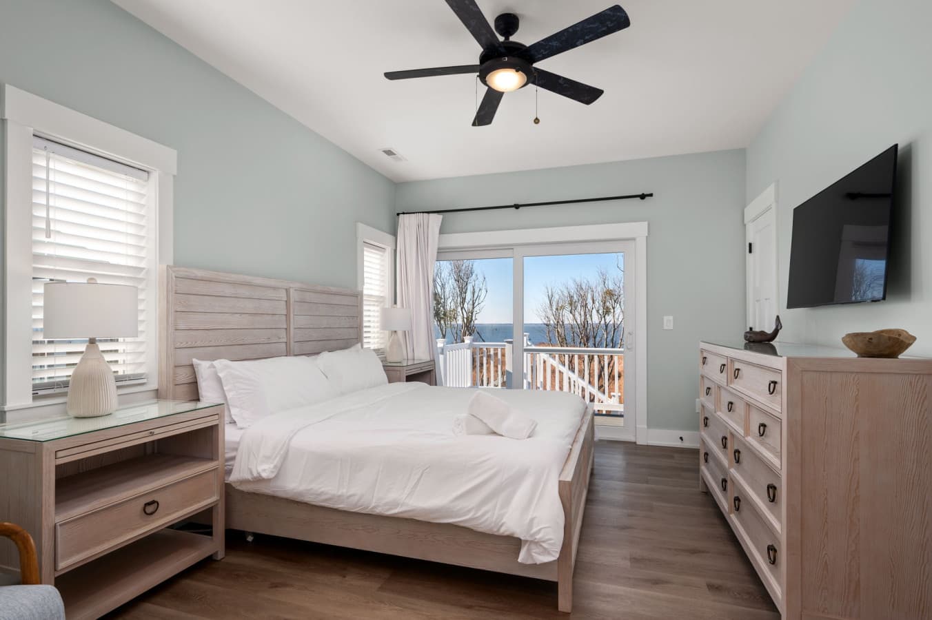 Serene bedroom w/ crisp linens, soft light, & calming tones for restful nights by the coast