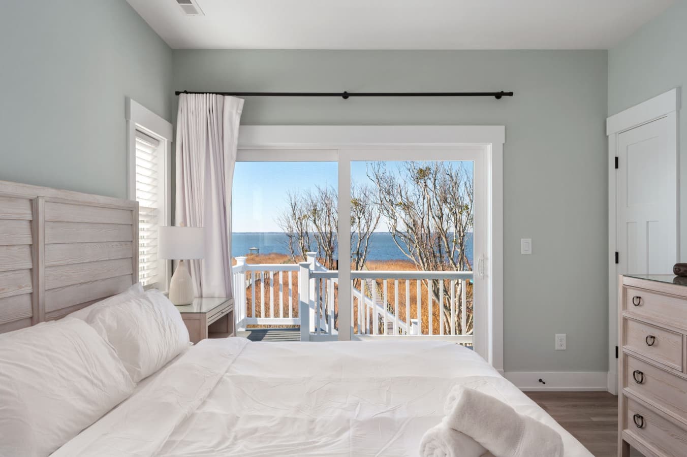 Bright bedroom w/ cozy bed & balcony access for fresh air & natural light