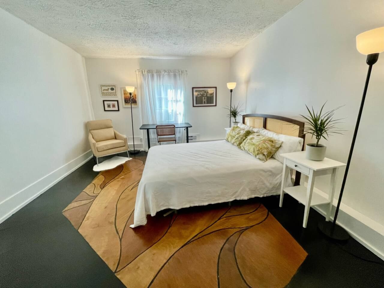 View of the second bedroom, with a large standing desk and spacious dresser