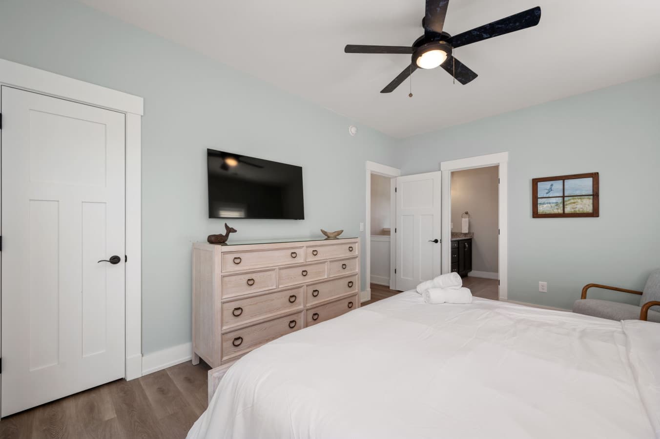 Calm bedroom w/ dresser, TV, & soft coastal tones for easy relaxation