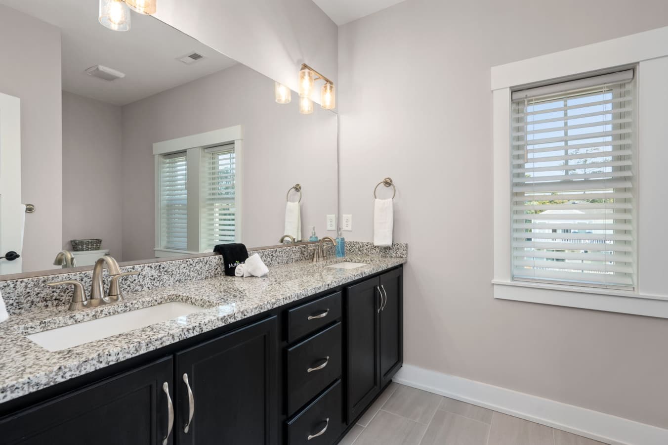 Spacious double vanity w/ granite counters & bright lighting for smooth mornings
