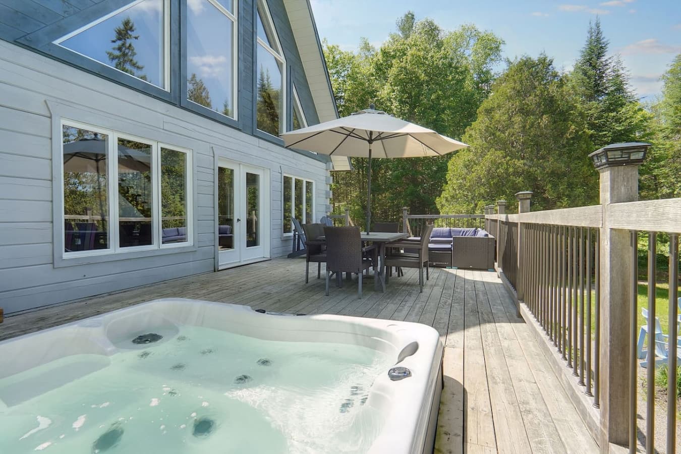 Large deck with hot tub overlooking the lake