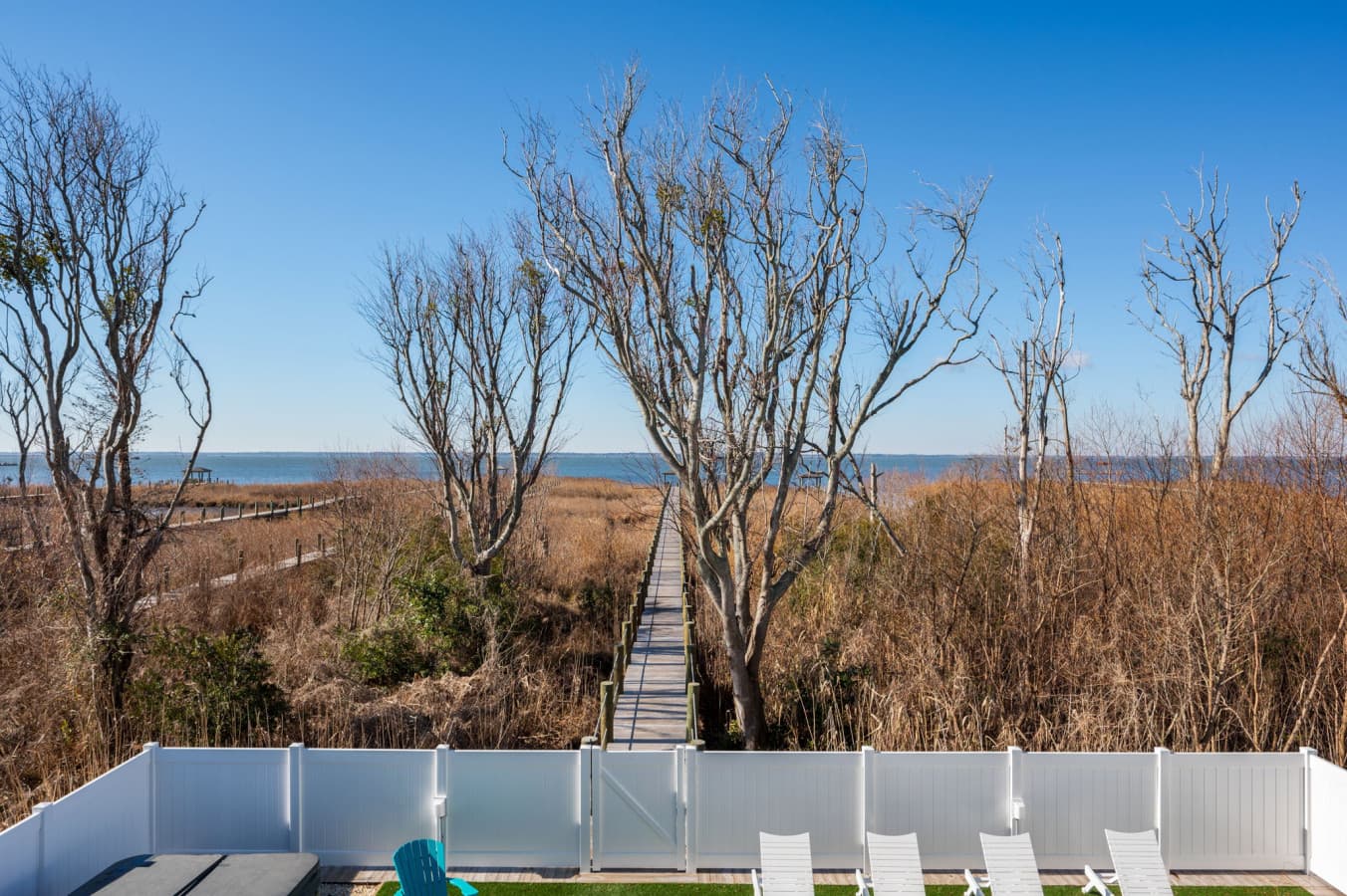 Upper-deck view over the private pool & treetops out to the water beyond