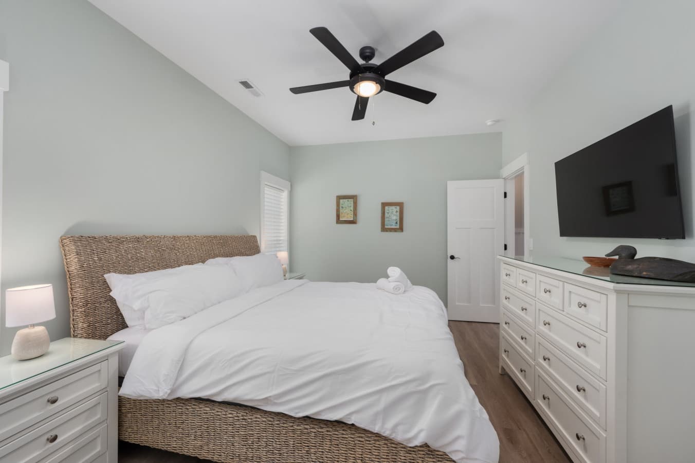 Spacious bedroom w/ woven headboard, vaulted ceiling & wall TV for unwinding at day's end