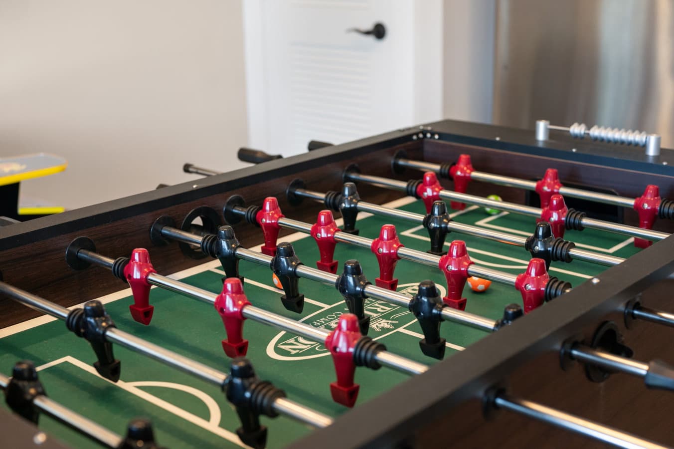 Detail of the foosball table w/ red & white players lined up for the next match