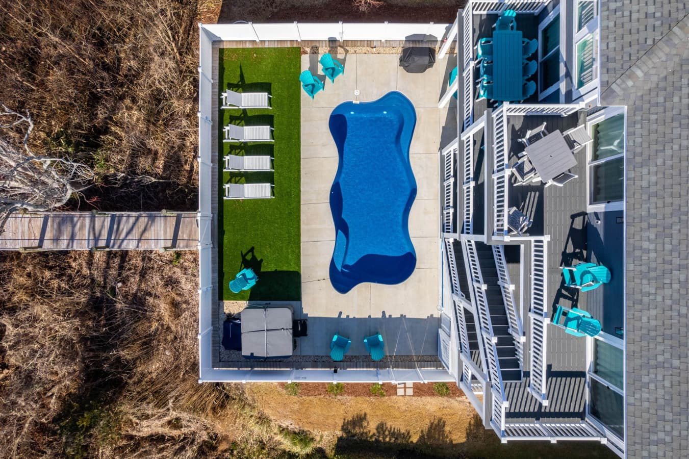 Aerial look down at the private pool, loungers & turf lawn tucked behind the house