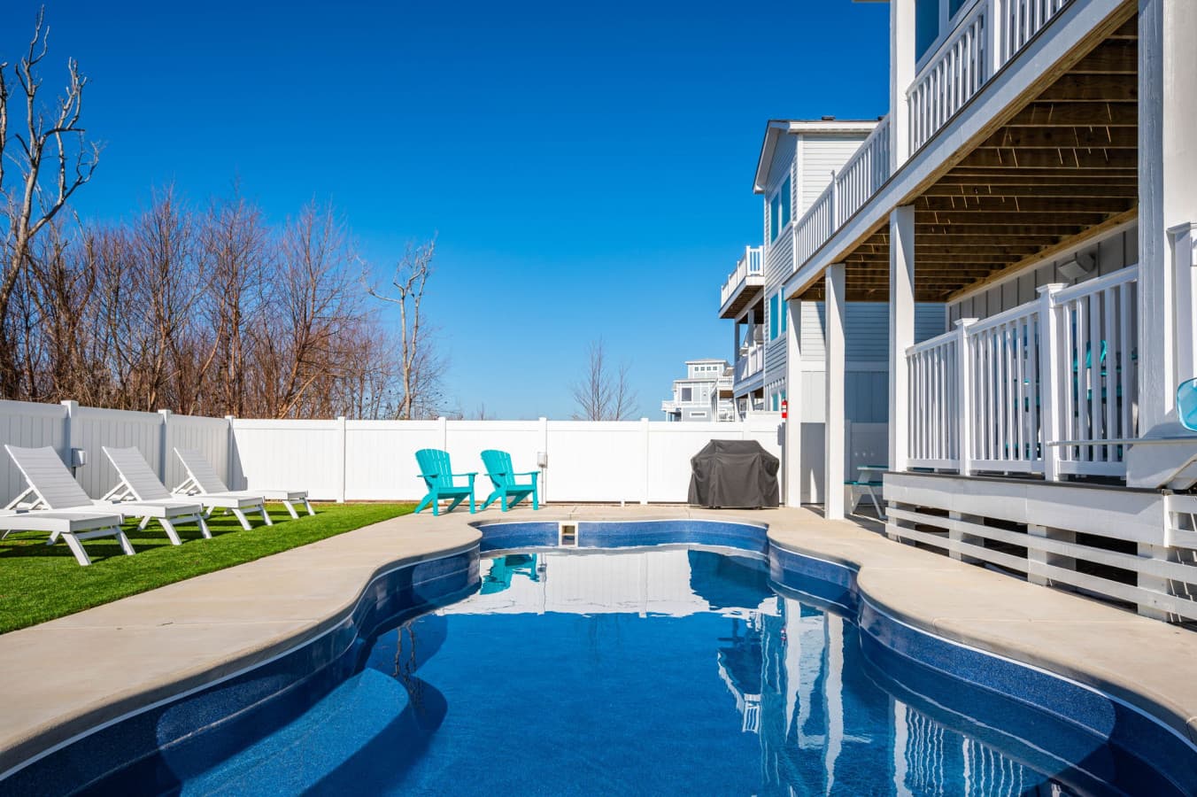 Private pool w/ loungers lining the fence & three levels of deck rising above