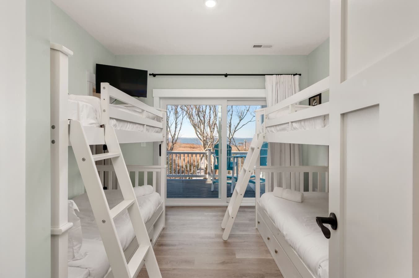 Bunk room w/ twin-over-twin beds, ladder access & a window onto the deck