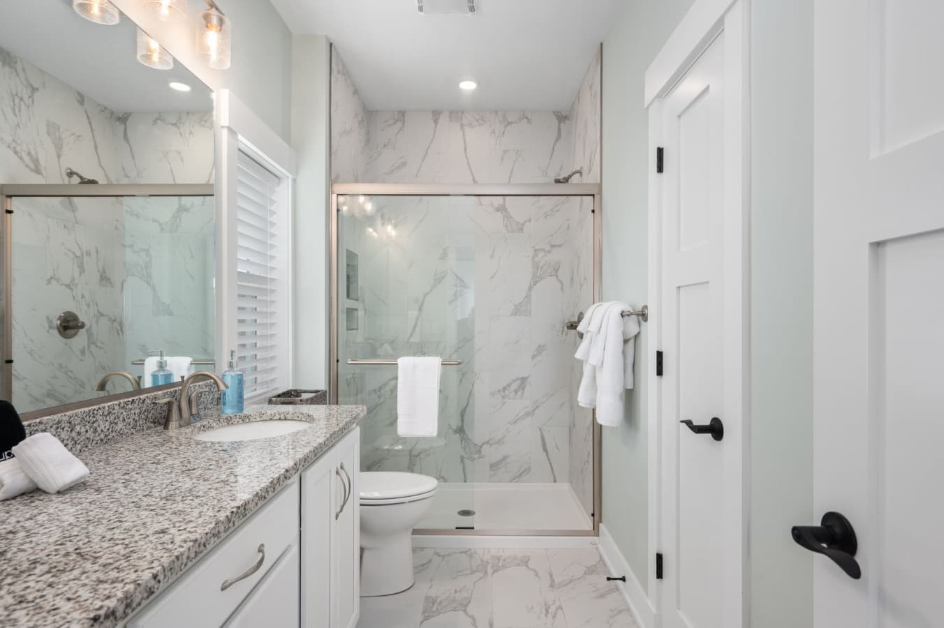 Bath w/ marble walk-in shower, glass door & granite vanity in soft neutrals