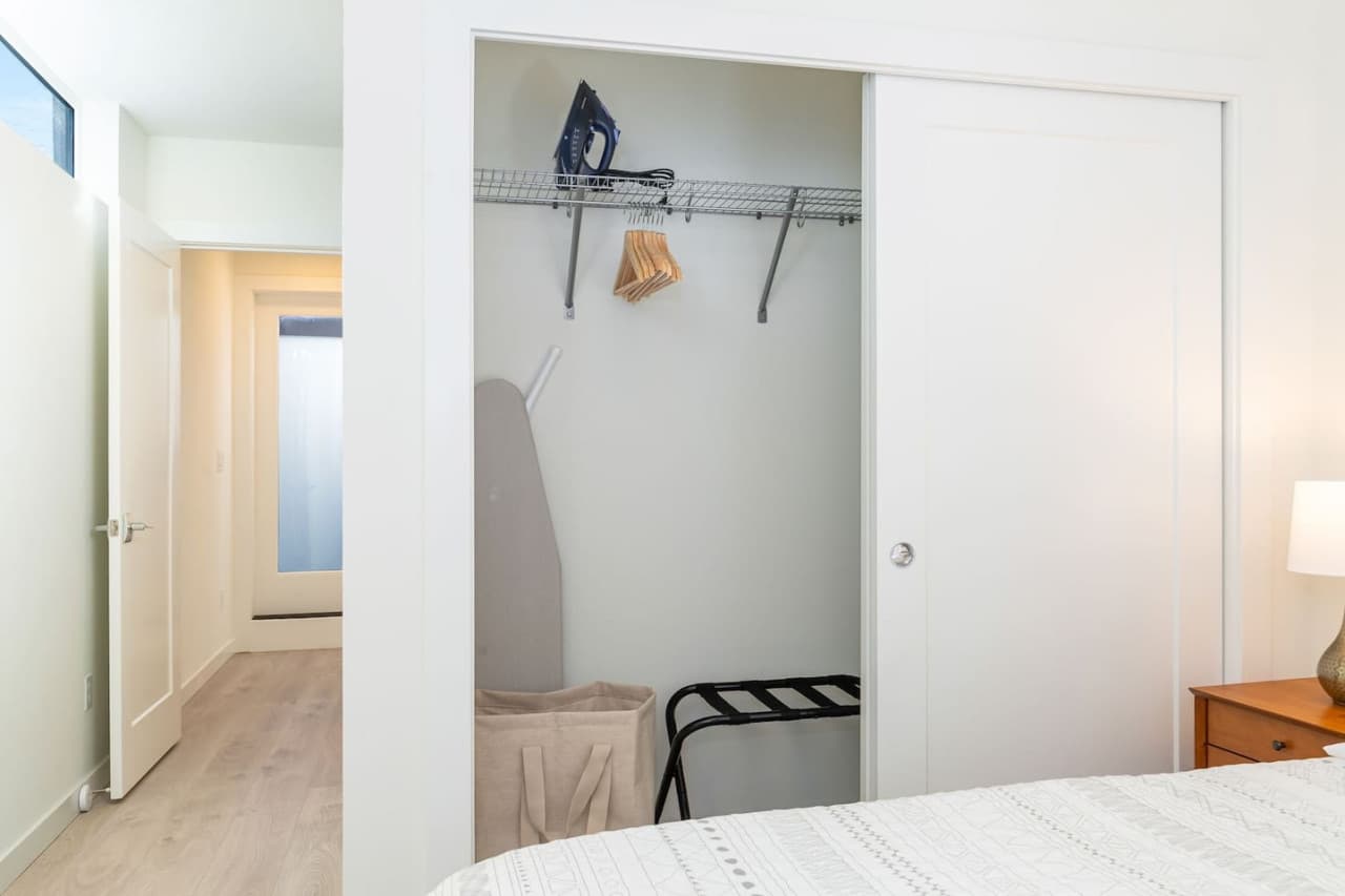 Closet with iron and luggage racks.