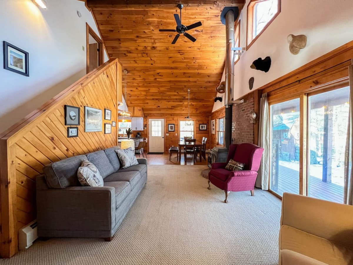 Living room 2 of 2 includes stairway to 2nd Master Suite and a sitting area in front of our wood burning stove.