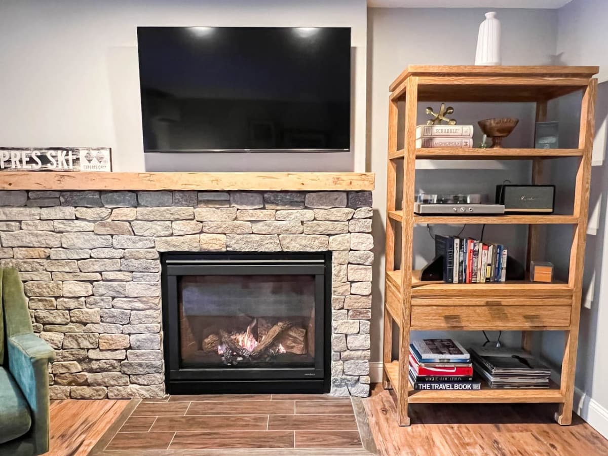 A view of our new fireplace, Smart TV, and a bookcase full of records, books, and games.