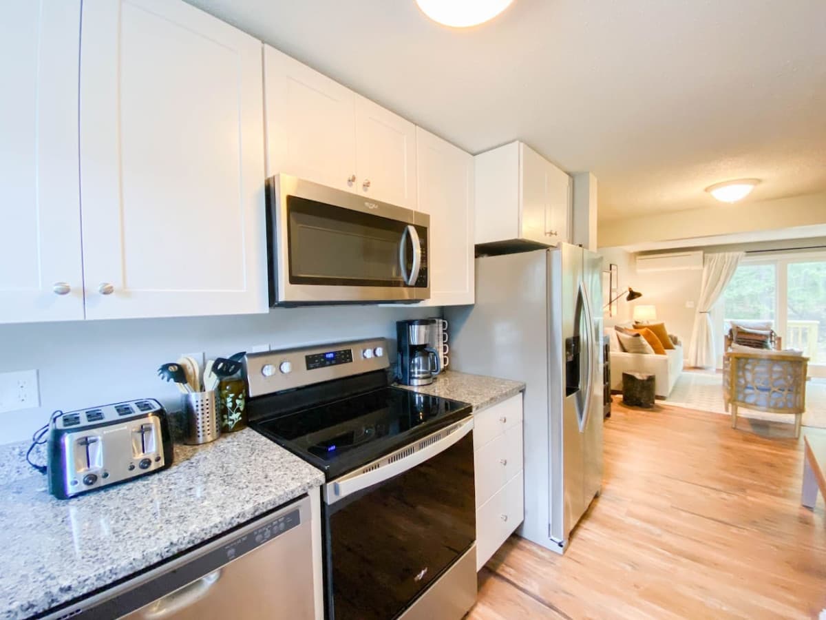 Brand new galley kitchen with sparkling clean appliances and granite countertops.