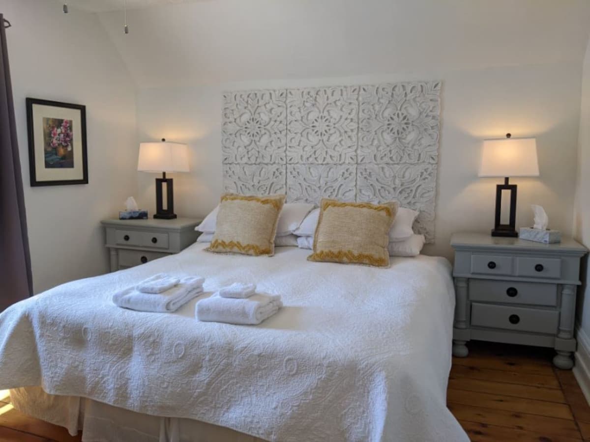 The upper level front bedroom features a king sized bed, closet, dresser and ceiling fan.