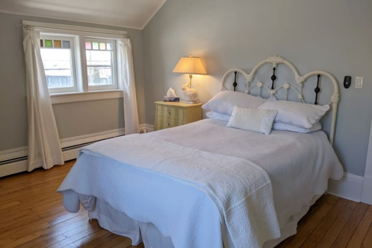 The upper level green room features a double bed and a wardrobe. In the warmer months, a window air conditioner is installed here.