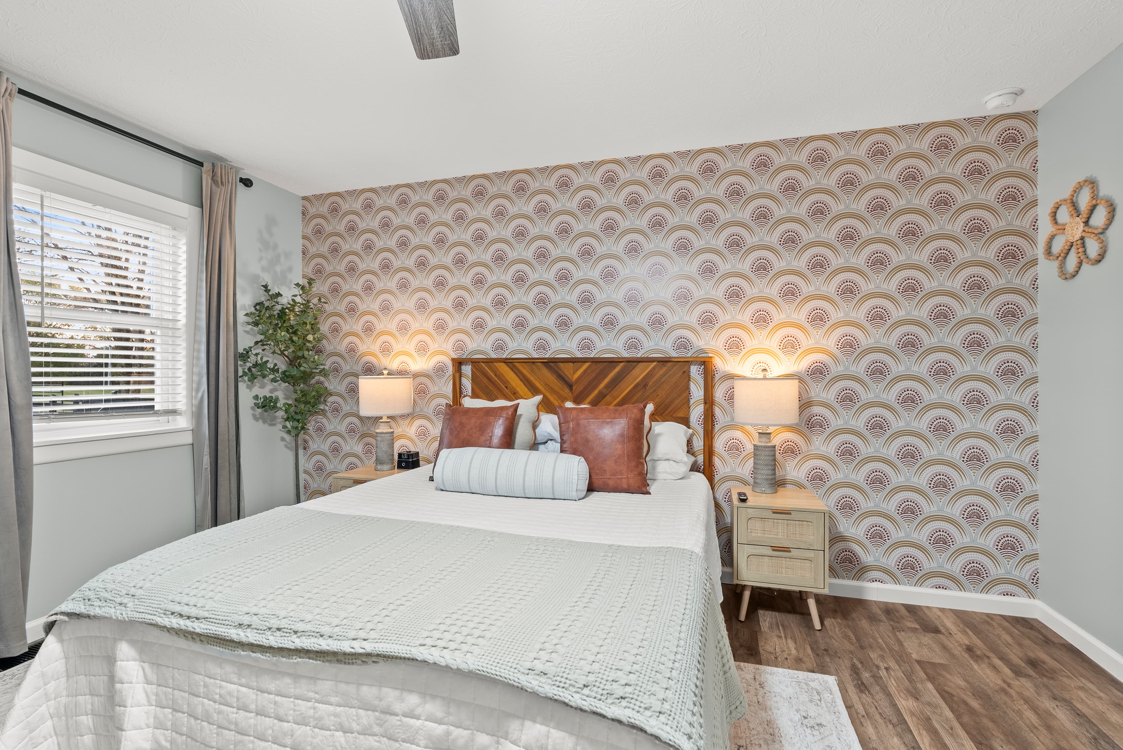 Main level west "Boho Bedroom" w/ queen sized bed. Roku smart TV, dresser, night stands, w/lamps. 
