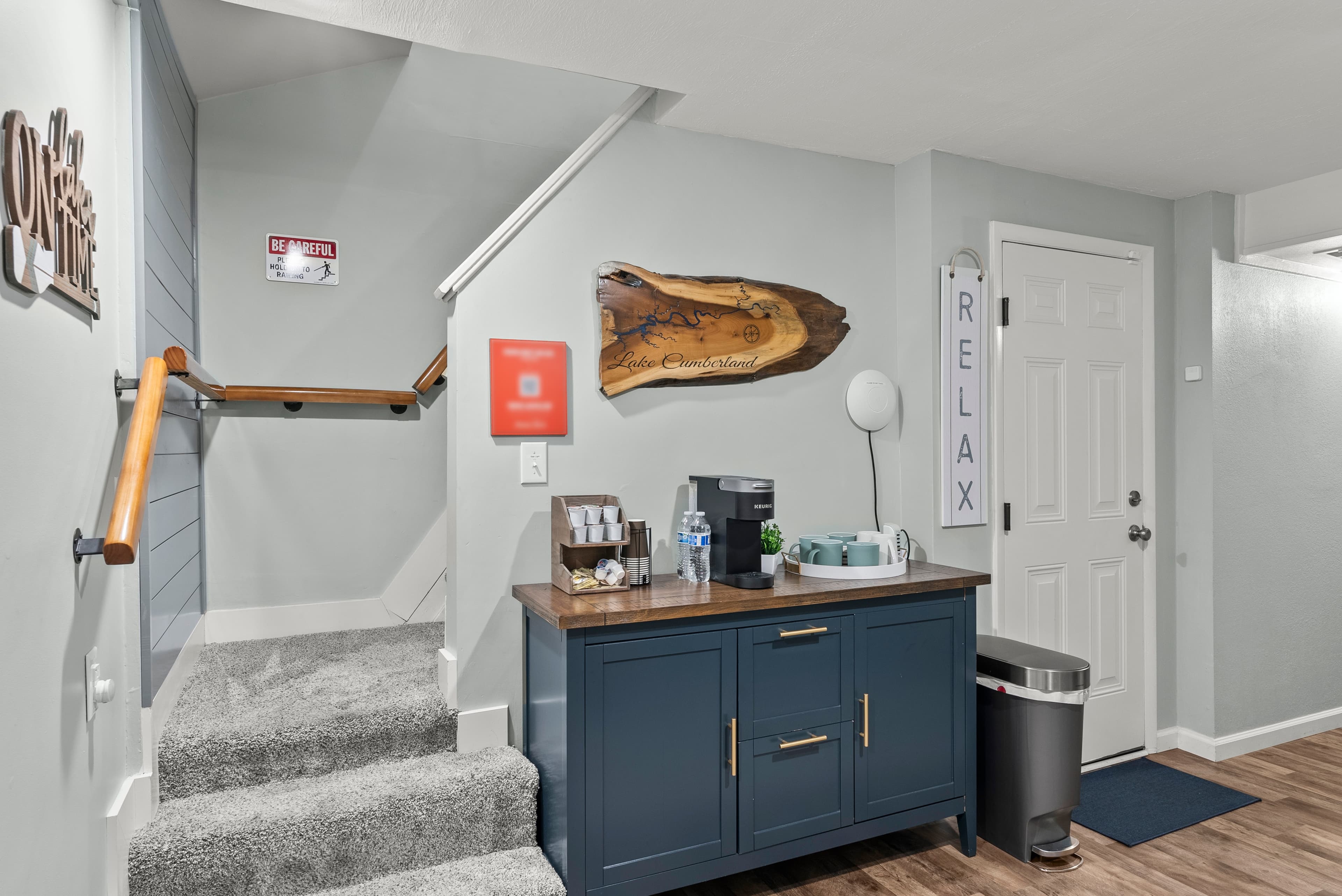Cozy lower-level coffee nook with single-cup Keurig, mugs, sugar, creamer, and USB charging ports.