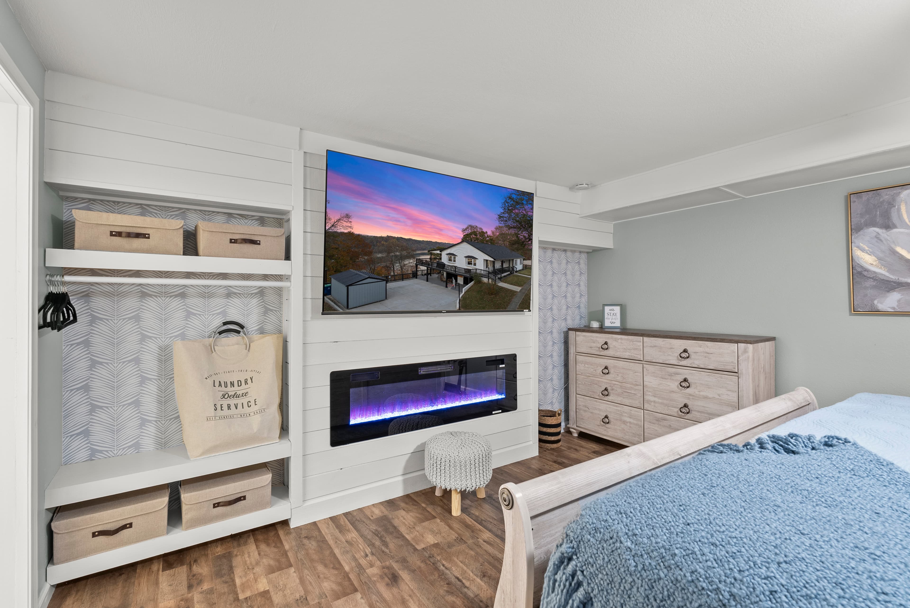 Lower level king bedroom w/ ensuite bath, dresser, hanging area, luggage racks, LED heated fireplace