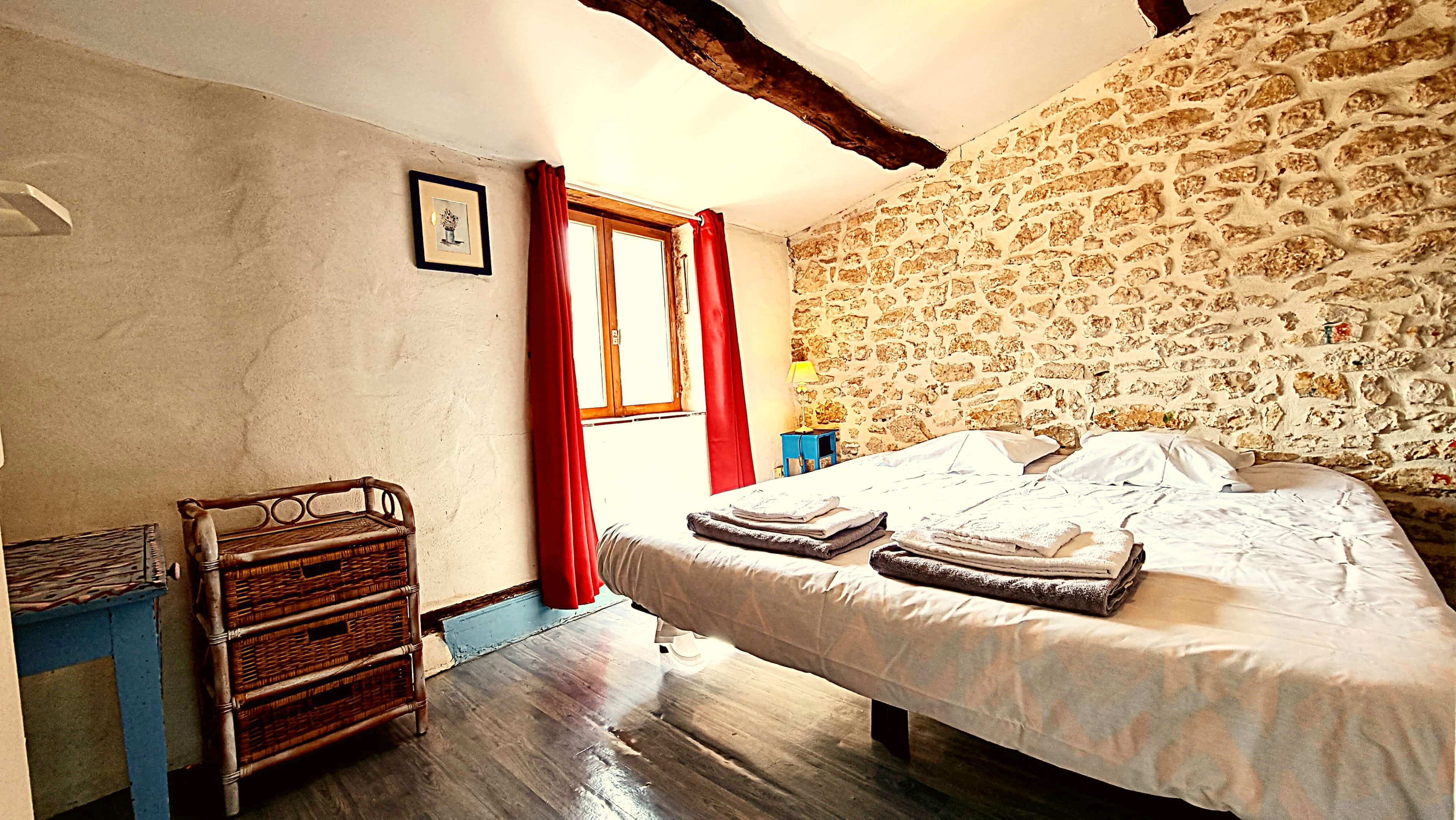 Stone-walled bedroom with red shutters