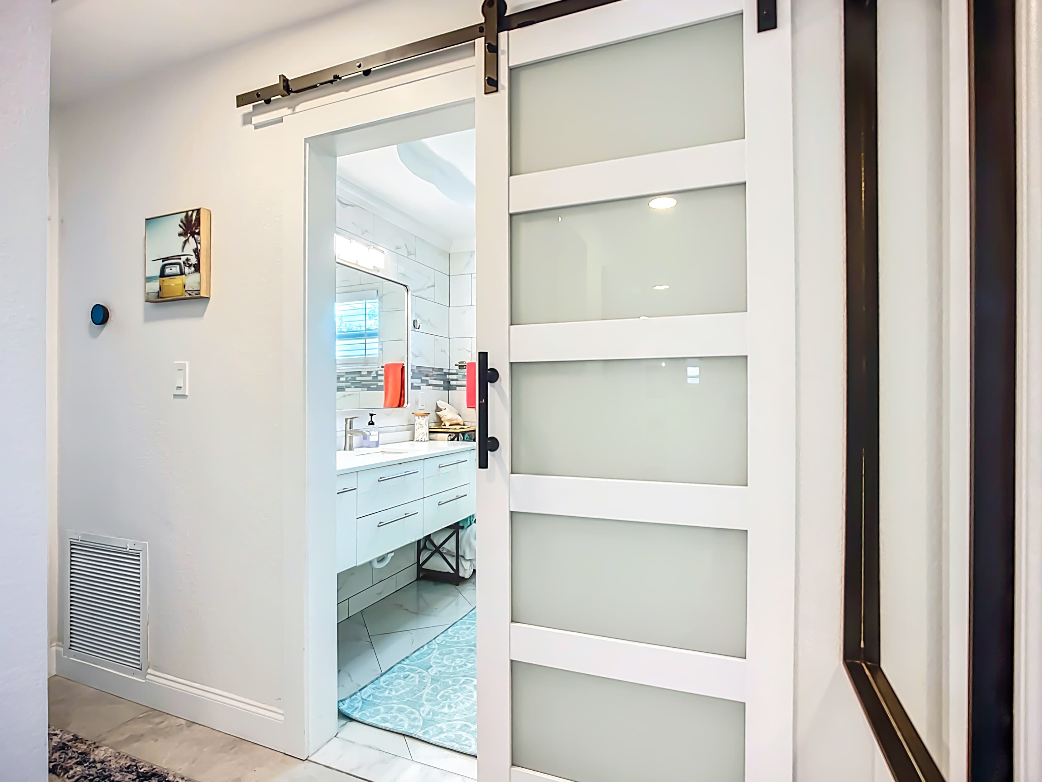 Hallway with Nest Thermostat and sliding glass barn door & full size mirror