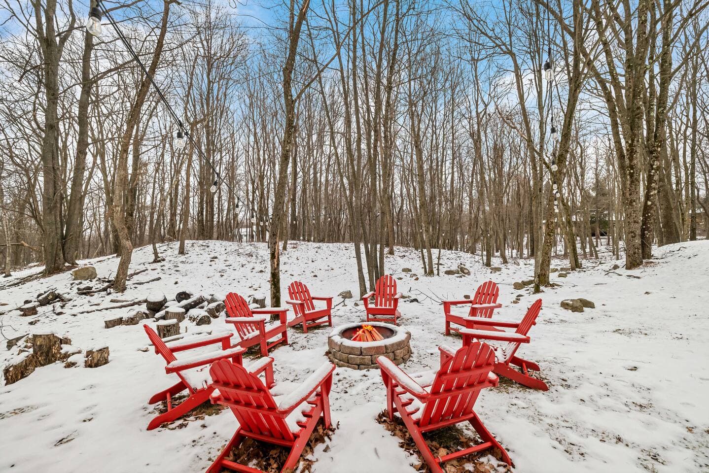 Gather around the outdoor firepit, surrounded by cozy Adirondack chairs, and enjoy the serene winter