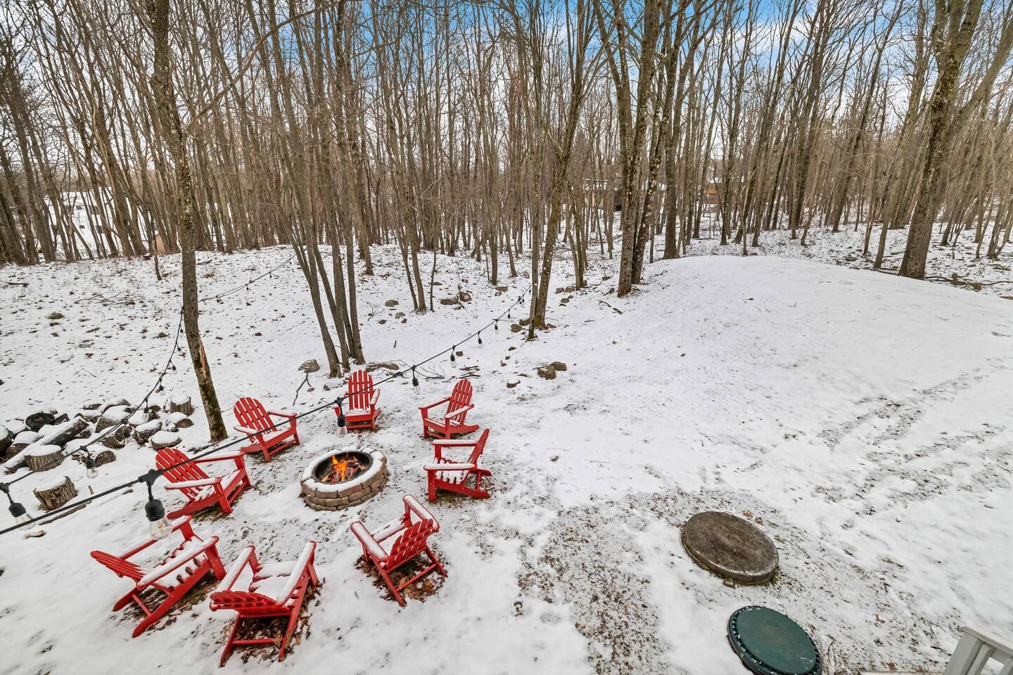 Gather around the outdoor firepit, surrounded by cozy Adirondack chairs, and enjoy the serene winter