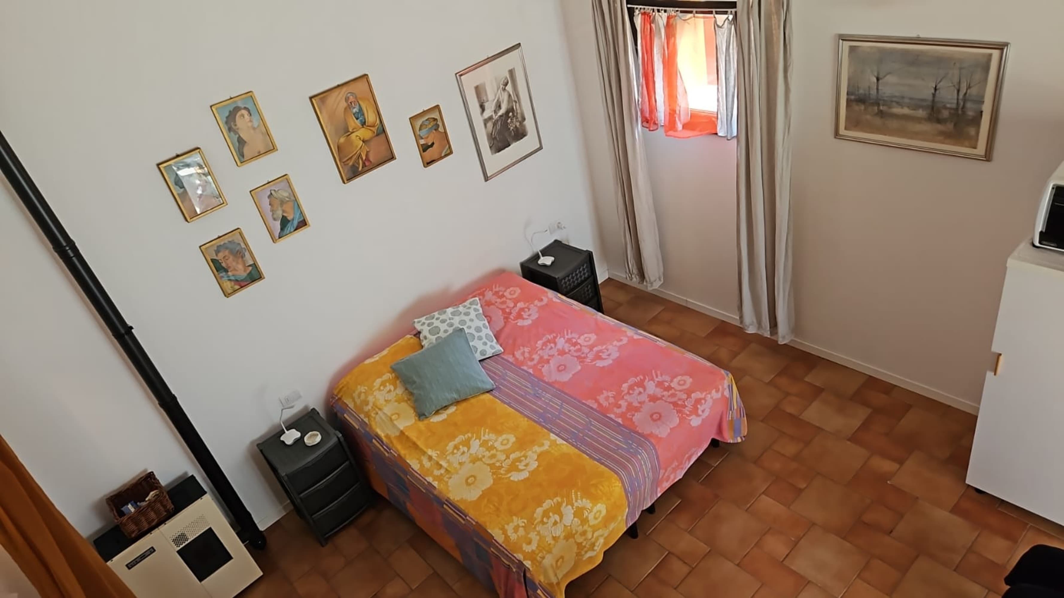 sight from upstairs, artworks, curtains, king size bed, stove on the left