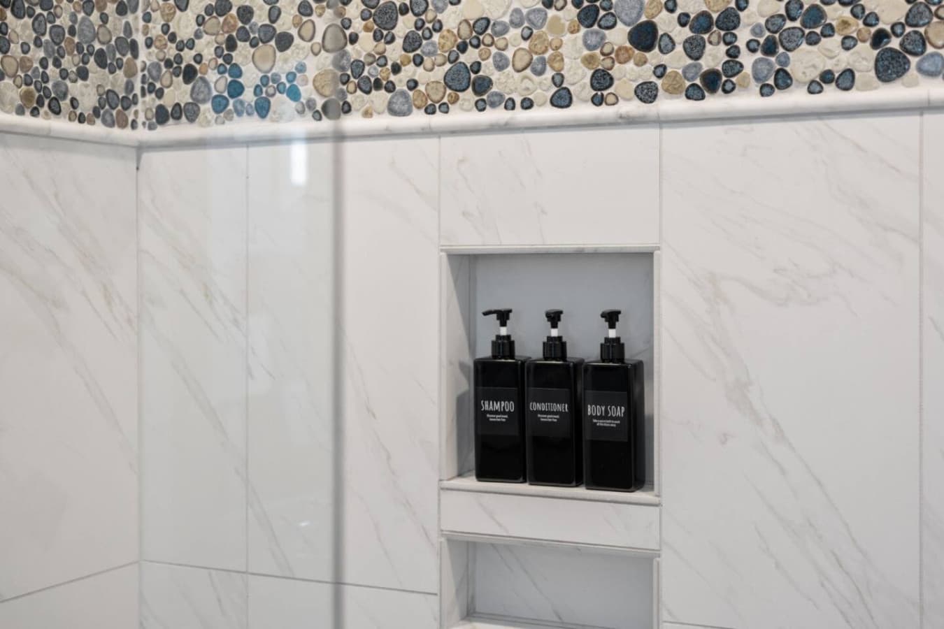 Sleek shower niche stocked w/ shampoo, conditioner & body wash