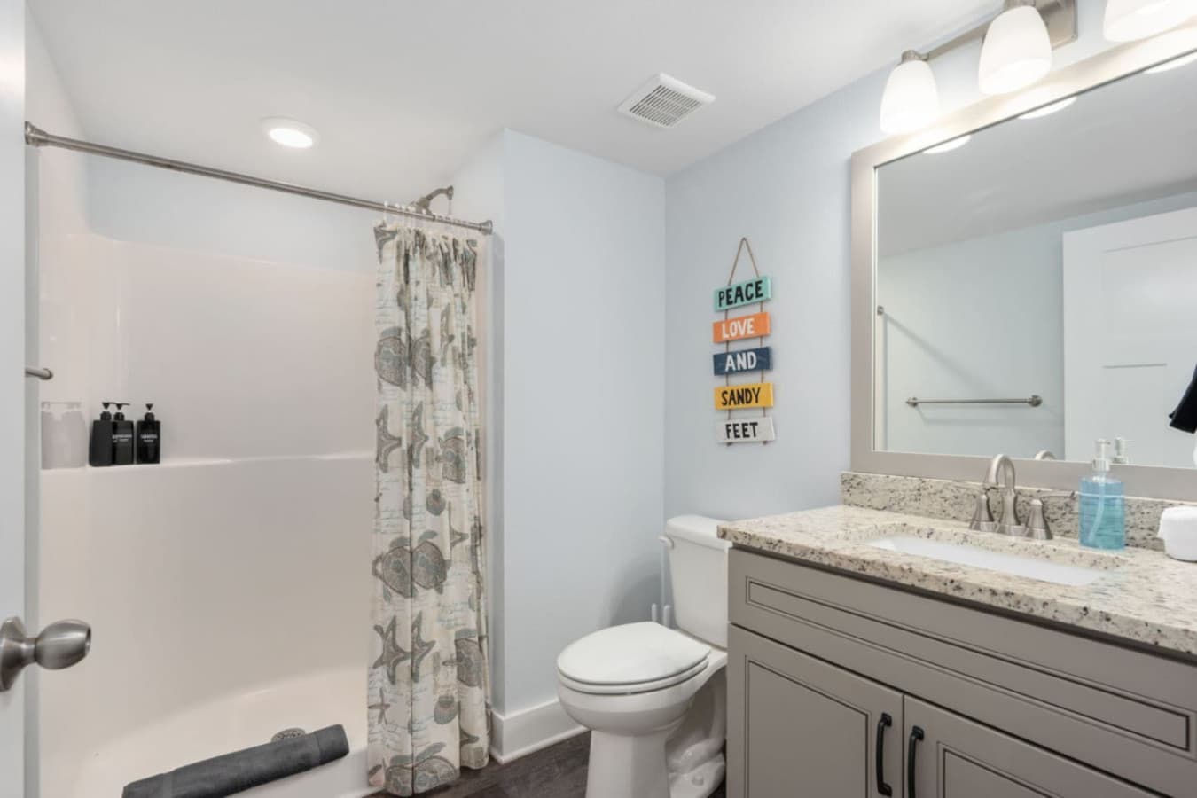 Bright bathroom w/ granite counter, large mirror & beachy accents