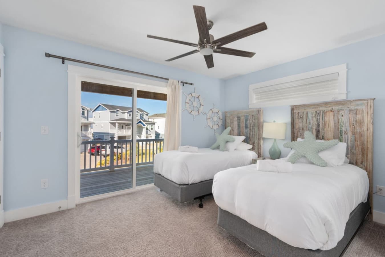Light-filled bedroom w/ balcony access, soft linens & coastal charm