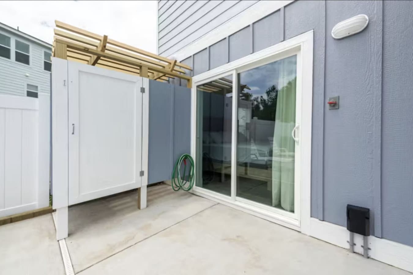 Ground-level patio w/ enclosed outdoor shower & a slider inside for rinsing off after the water.