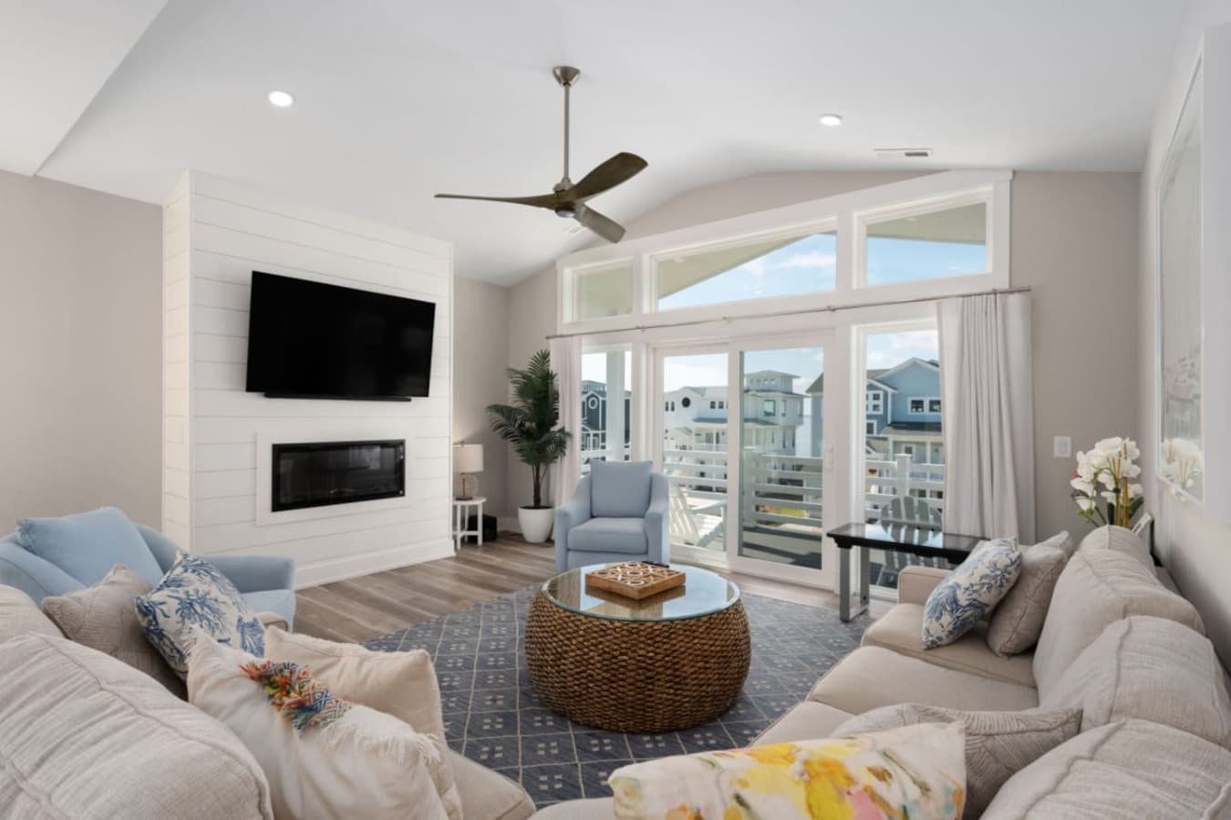 Inviting lounge space w/ soft textures, ceiling fan & natural light throughout.