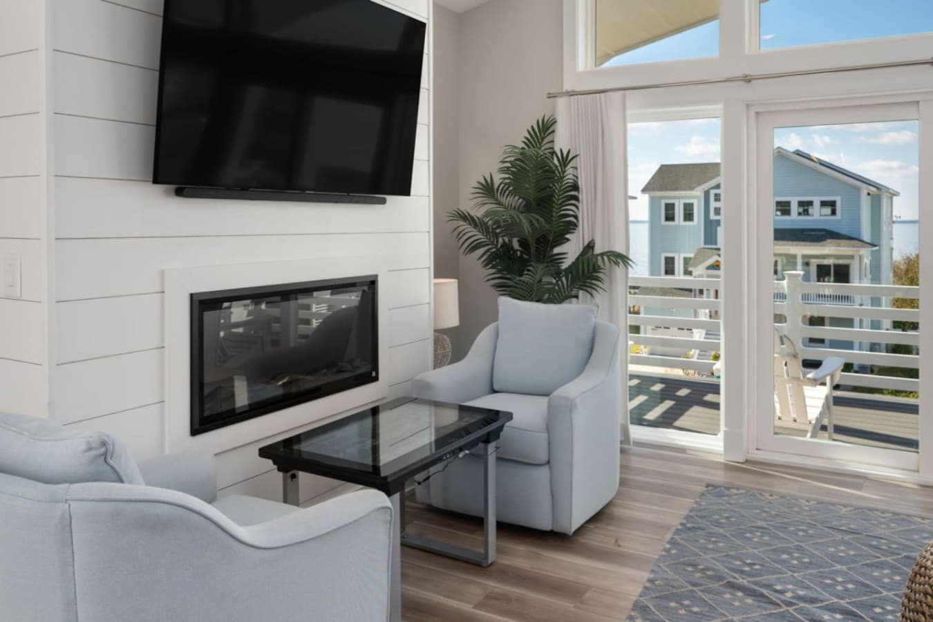 Living room corner w/ TV, comfy chair & easy access to outdoor seating.