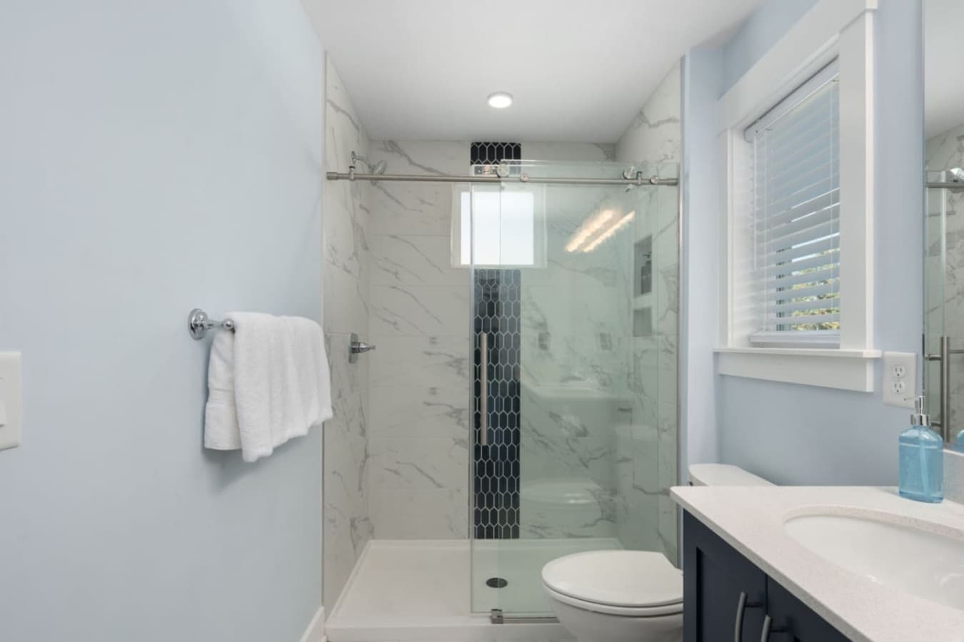Glass-enclosed shower w/ sleek tile work for a fresh, spa-like start.