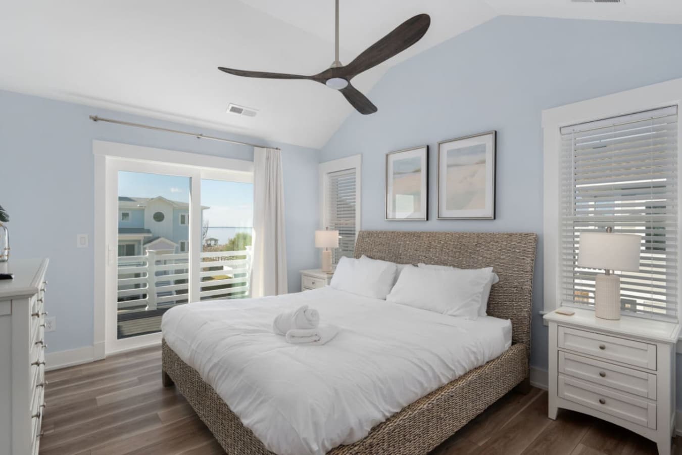 Serene bedroom w/ plush bed, ceiling fan & natural light throughout.
