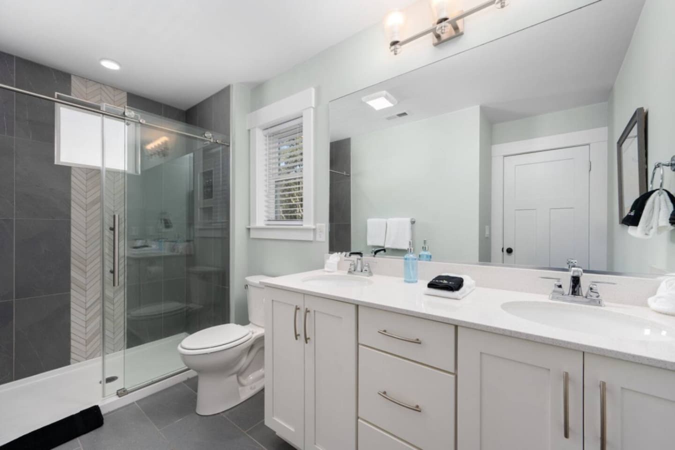 Spacious private bath w/ double sinks & bright, modern lighting.