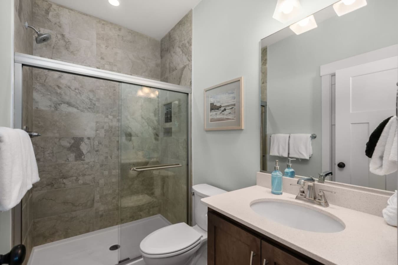 Spa-style bath w/ stone-look tile, glass shower & clean, modern finishes.