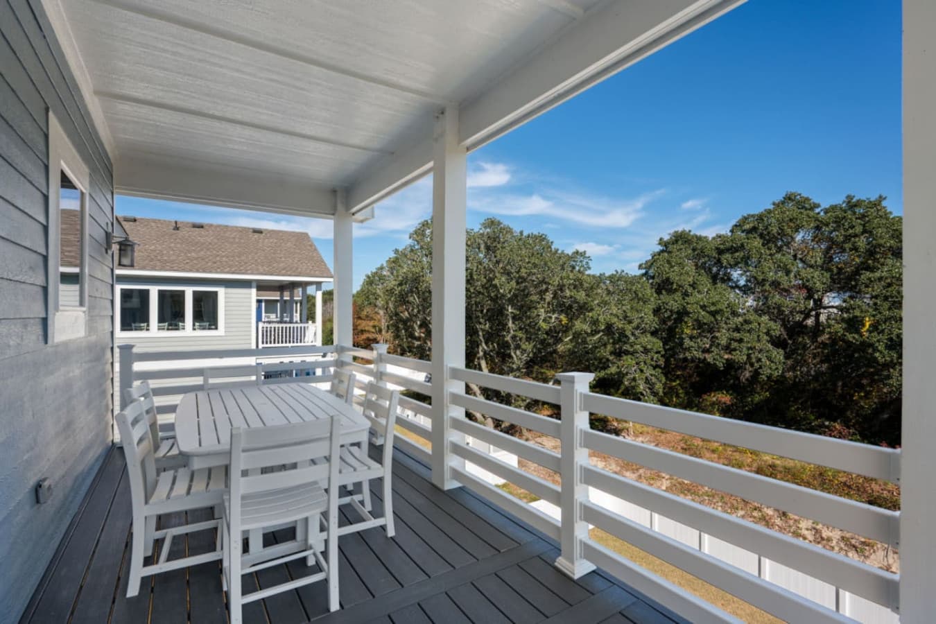 Covered deck w/ outdoor seating & peaceful neighborhood views.