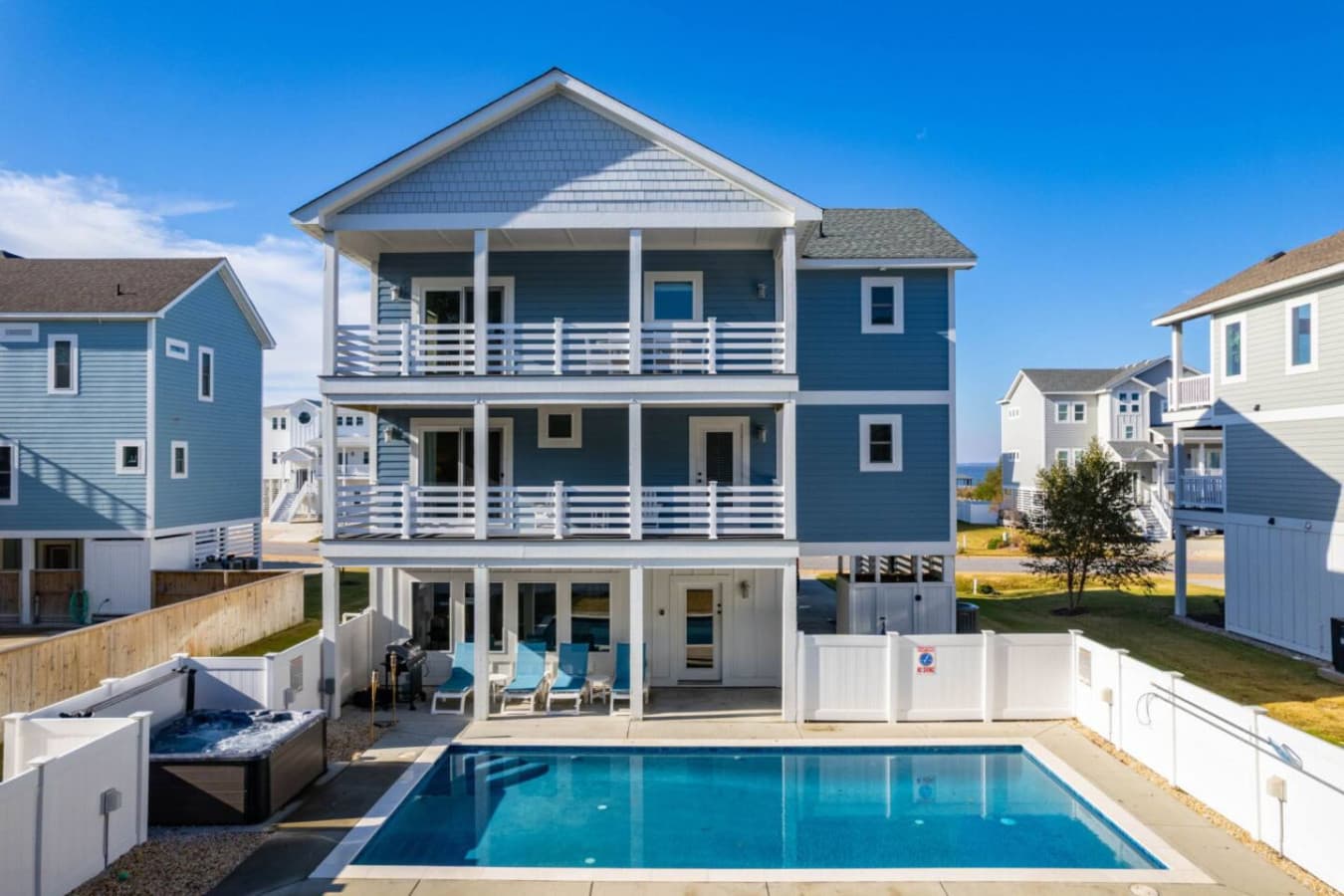 Full exterior view highlighting the home’s coastal design & private pool.