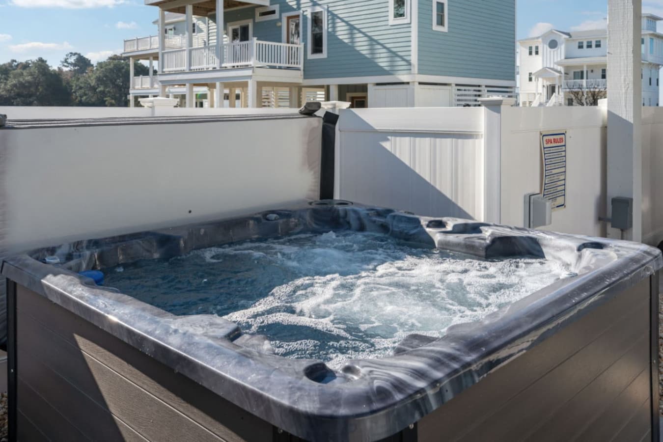 Private hot tub w/ jets running, screened by fencing for an unhurried evening soak.