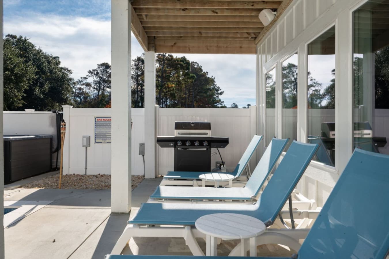Covered ground-level patio w/ gas grill, lounge chairs & shade right beside the hot tub.