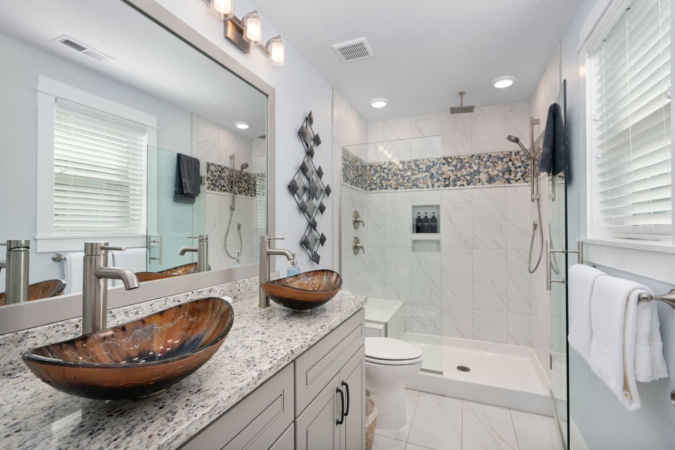 Modern bathroom w/ walk-in shower, glass doors & stylish tile details