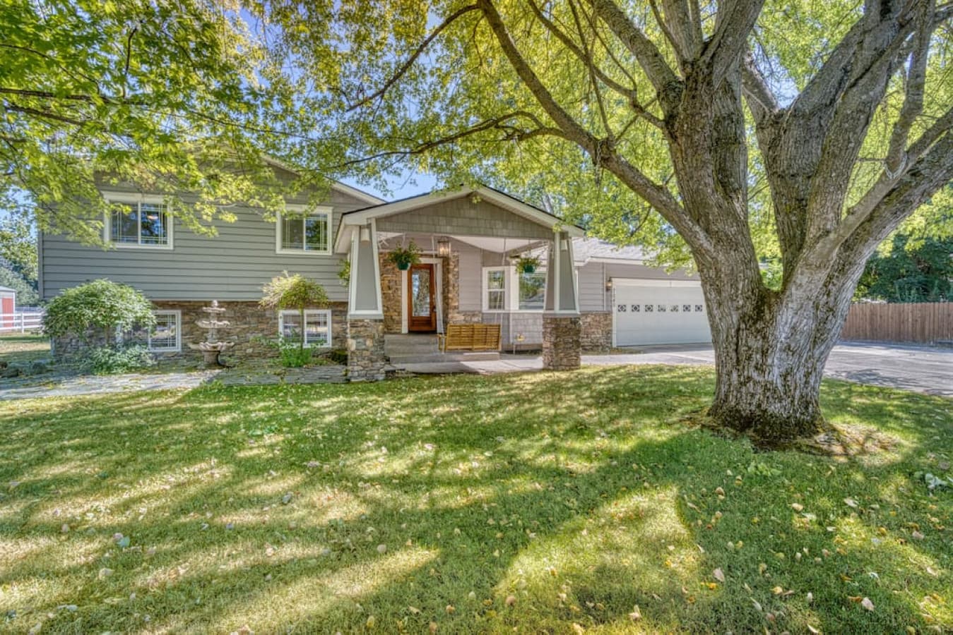 Front view of the house with swinging bench and large driveway