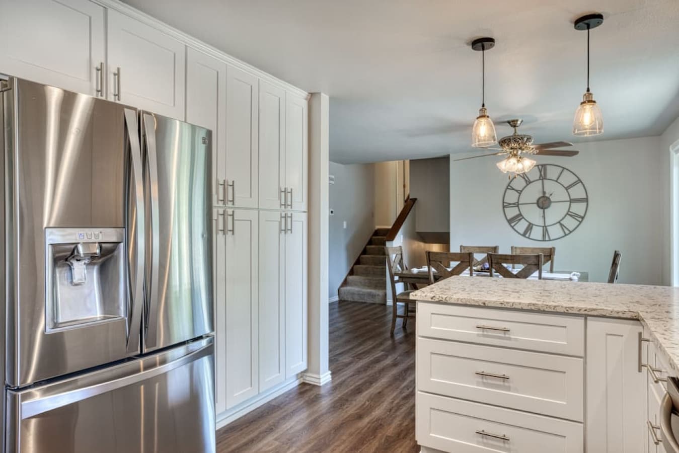 Large fridge & freezer with view towards dining area & stairs to upper/lower levels