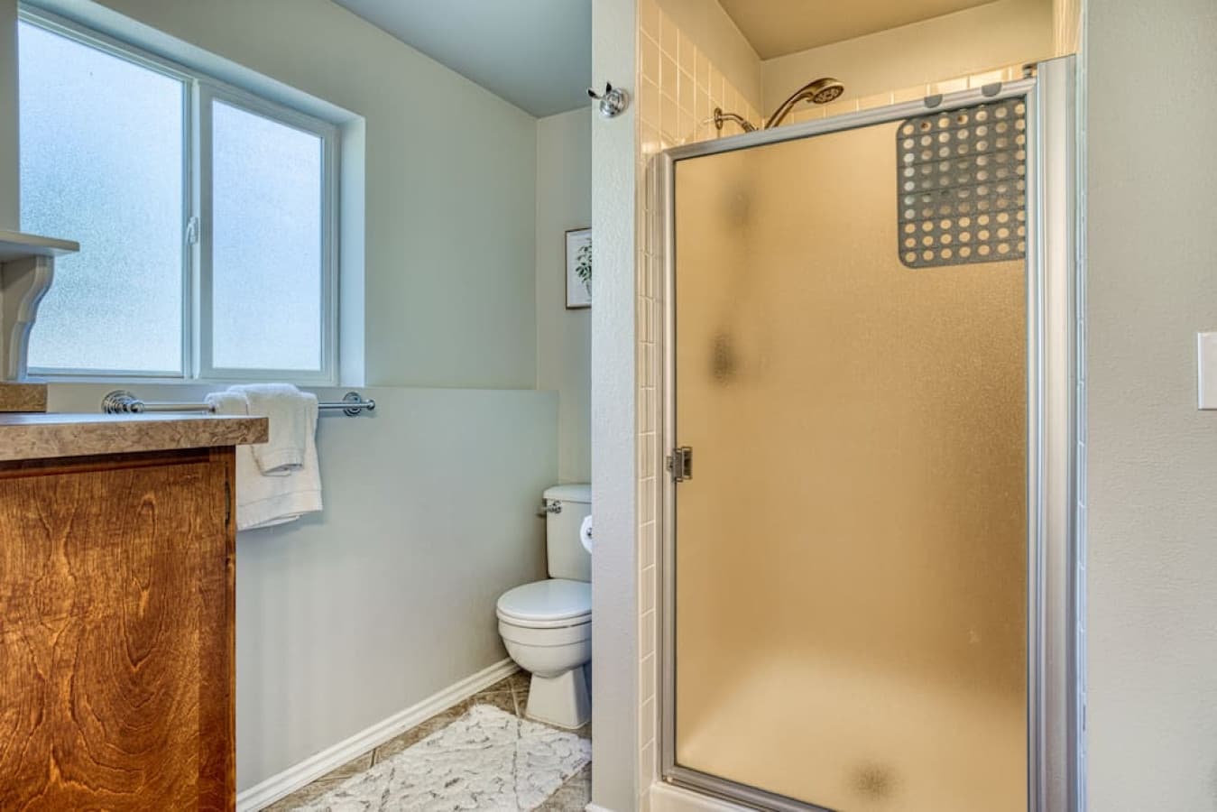 Shower and toilet in full bathroom/laundry area 1 level below the main floor