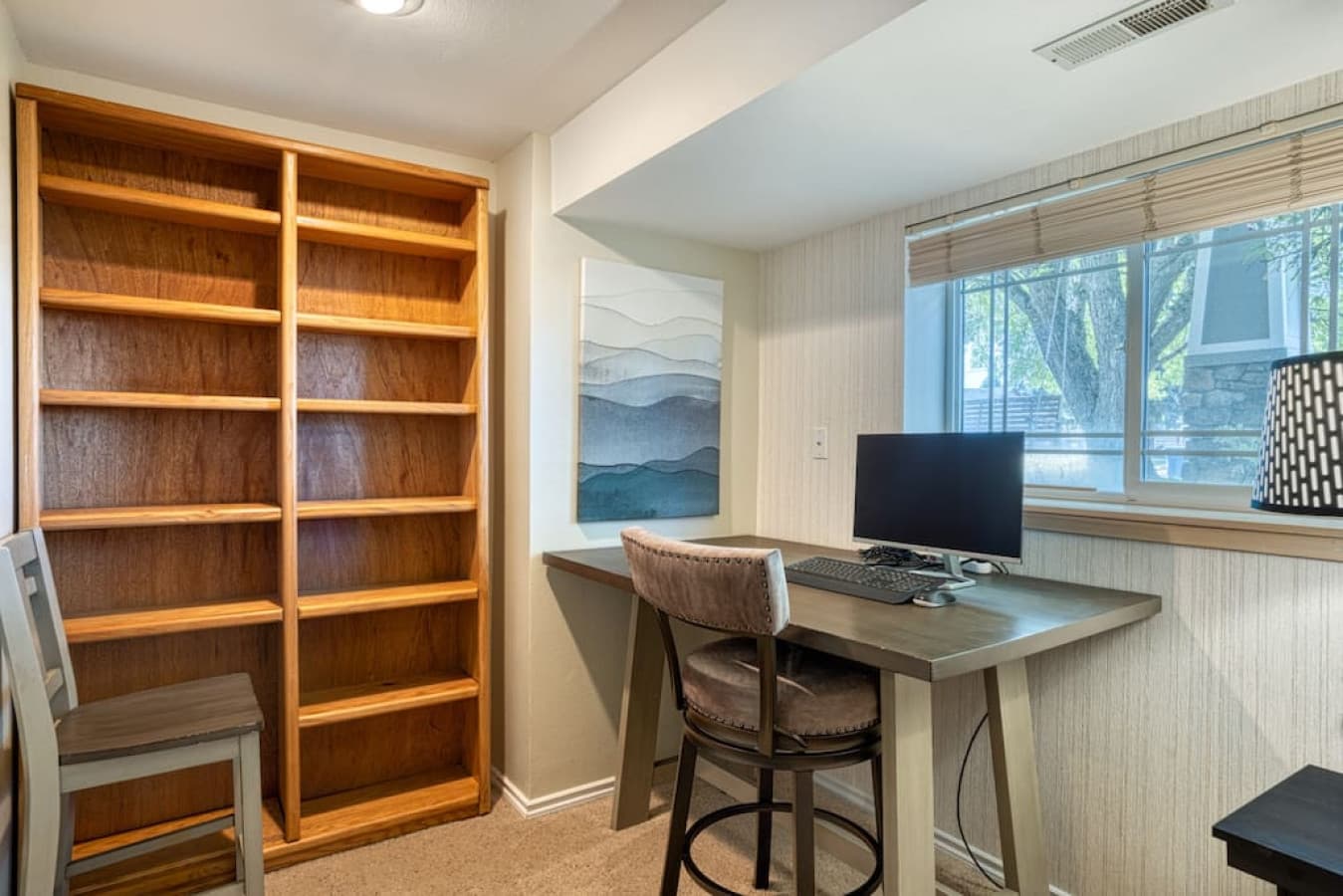 Dedicated workspace with desk, keyboard, monitor near living area 1 level down from main floor
