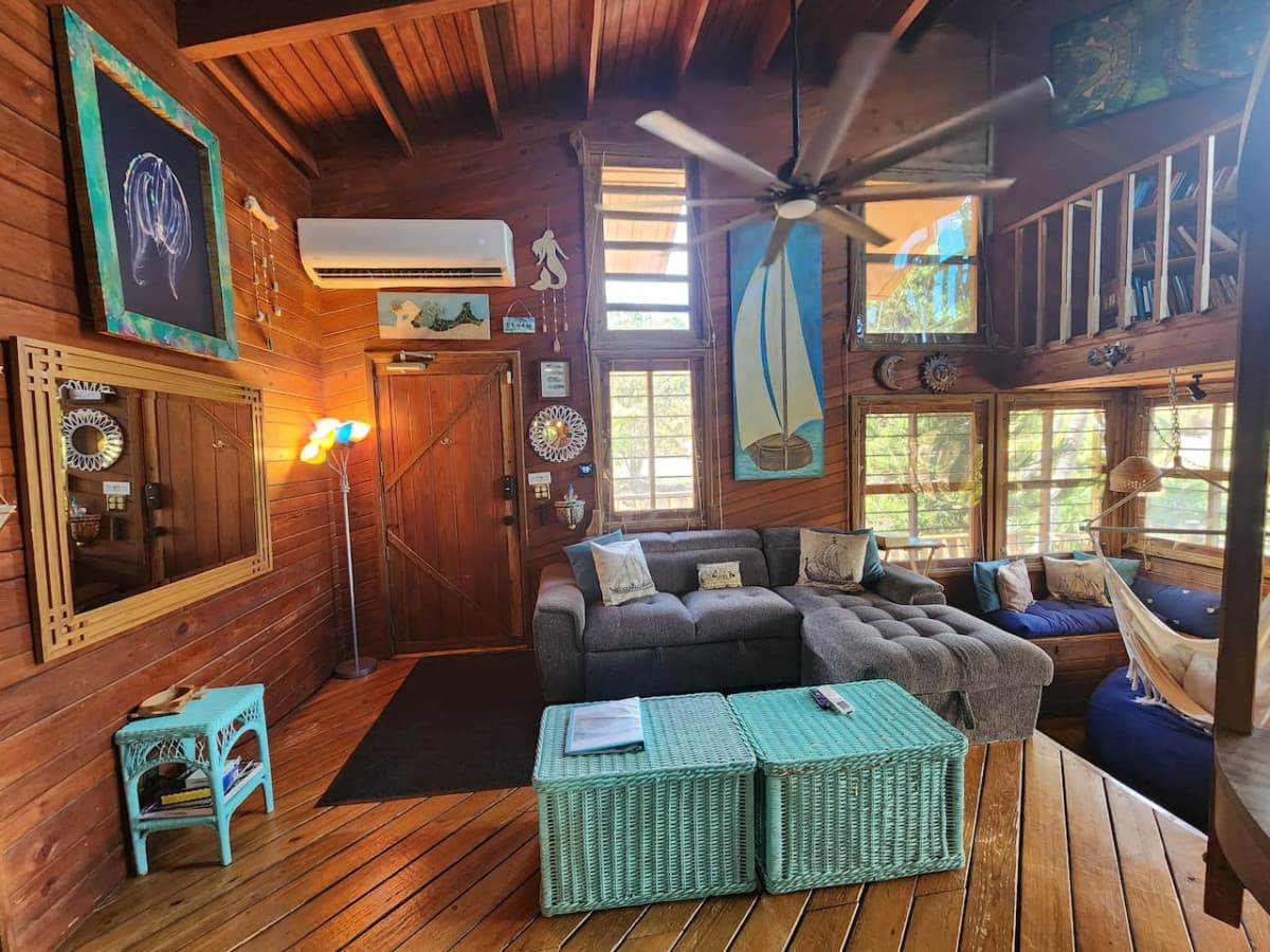 Living room with pull out queen sleeper sofa & queen bean bag chair! Enjoy the hammock & tons of local art pieces that decorate the walls to truly set the ISLAND VIBE!