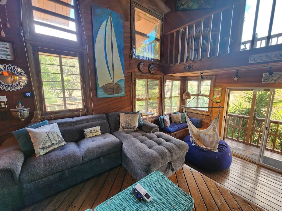 Living room with pull out queen sleeper sofa & queen bean bag chair! Enjoy the hammock & tons of local art pieces that decorate the walls to truly set the ISLAND VIBE!