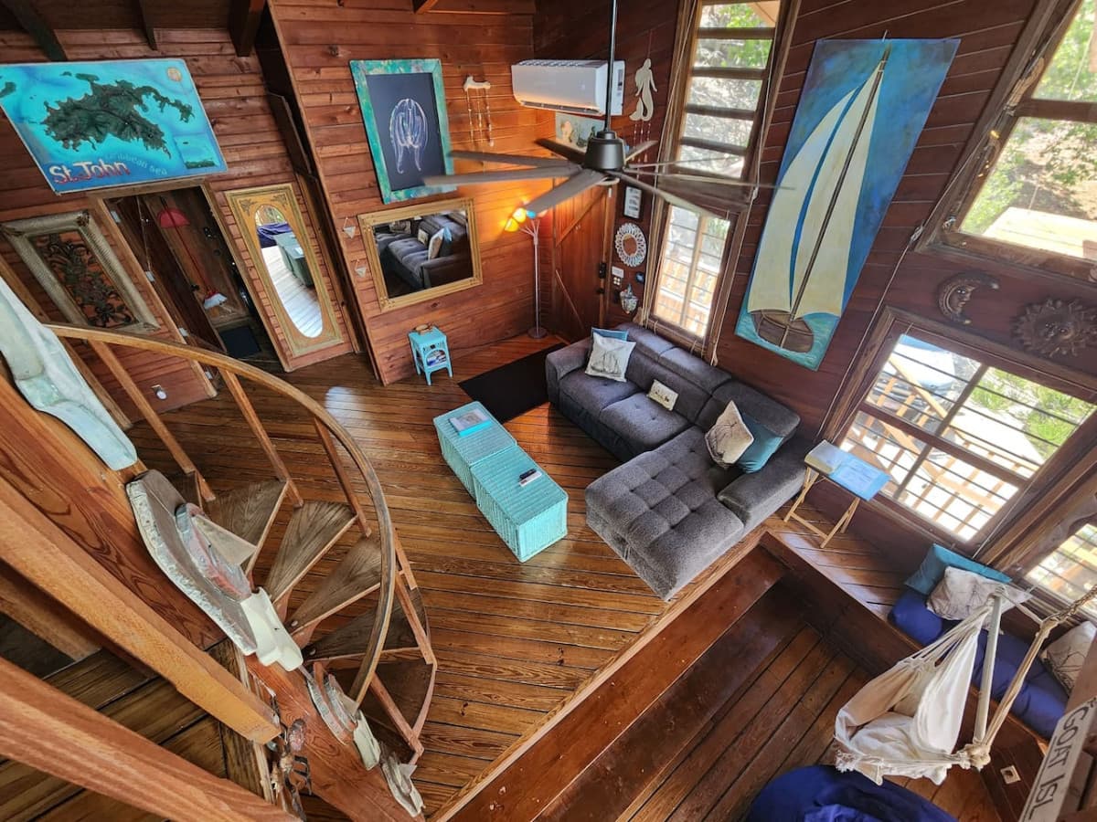 Living room with pull out queen sleeper sofa & queen bean bag chair! Enjoy the hammock & tons of local art pieces that decorate the walls to truly set the ISLAND VIBE!